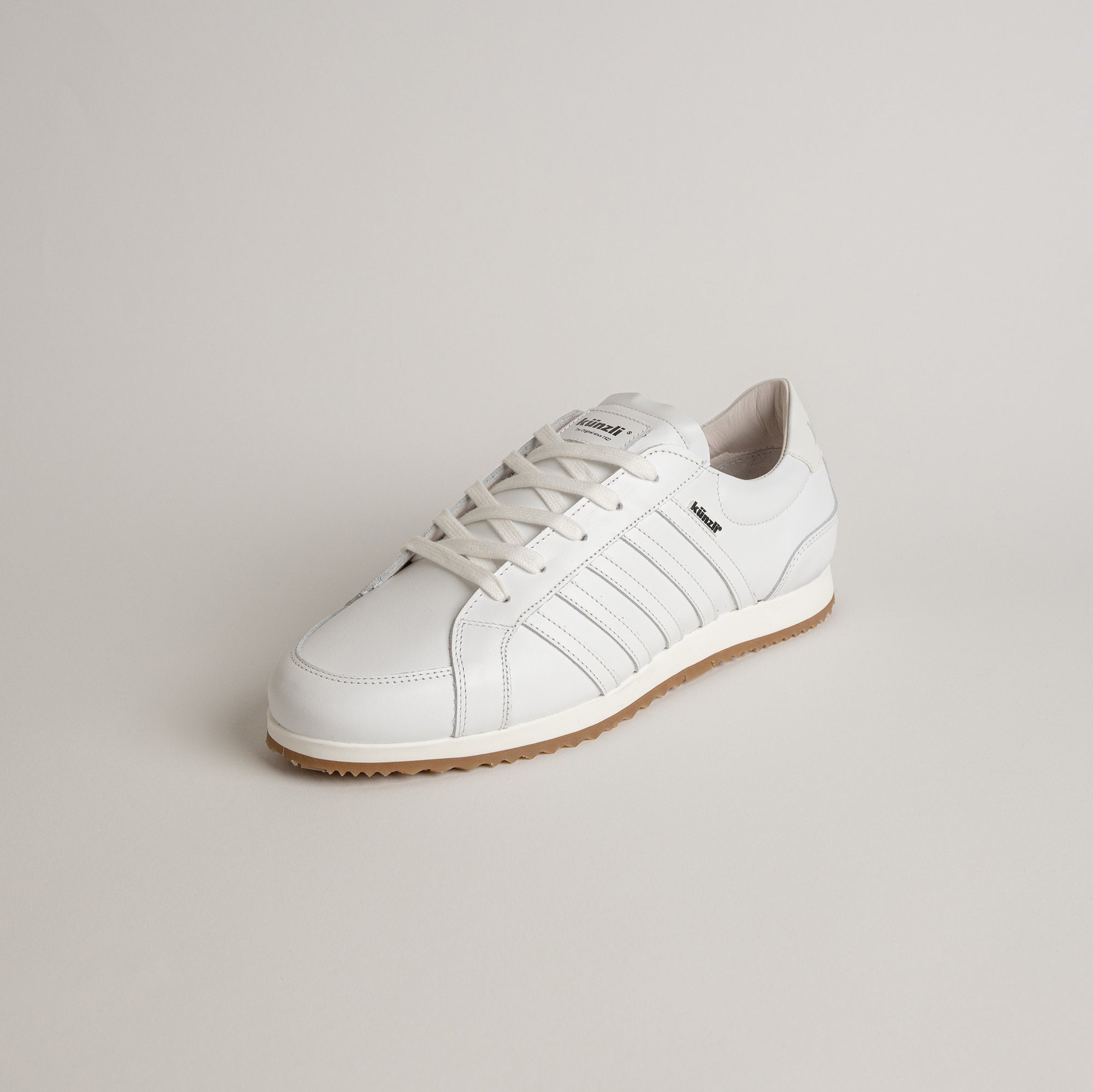Weißer Lederschuh von Kuenzli Schuhe auf hellem Hintergrund, sportlich und elegant gestaltet.