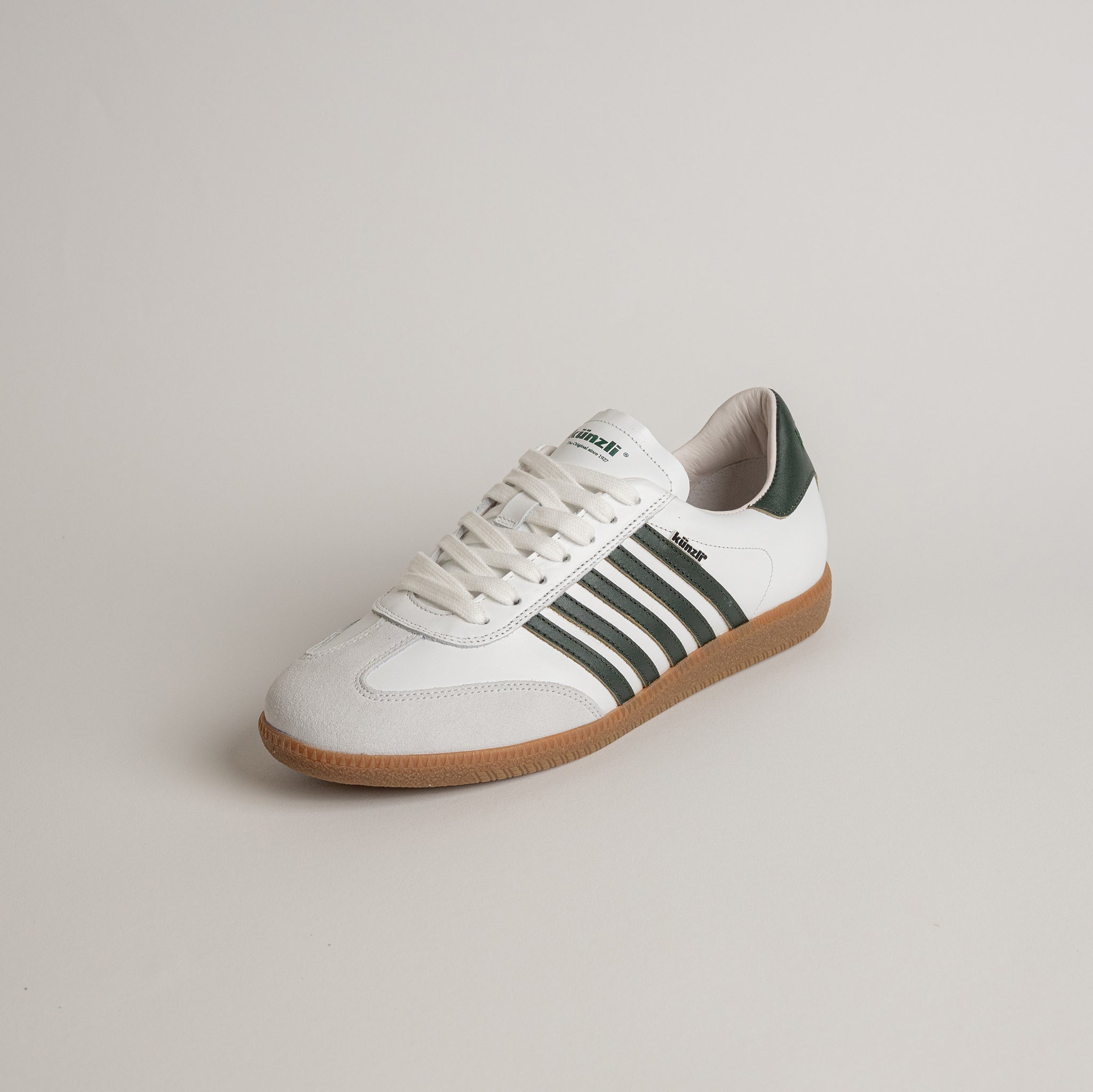 Weiß-grüner Kuenzli Schuhe Sneaker mit Streifen und brauner Sohle auf neutralem Hintergrund.