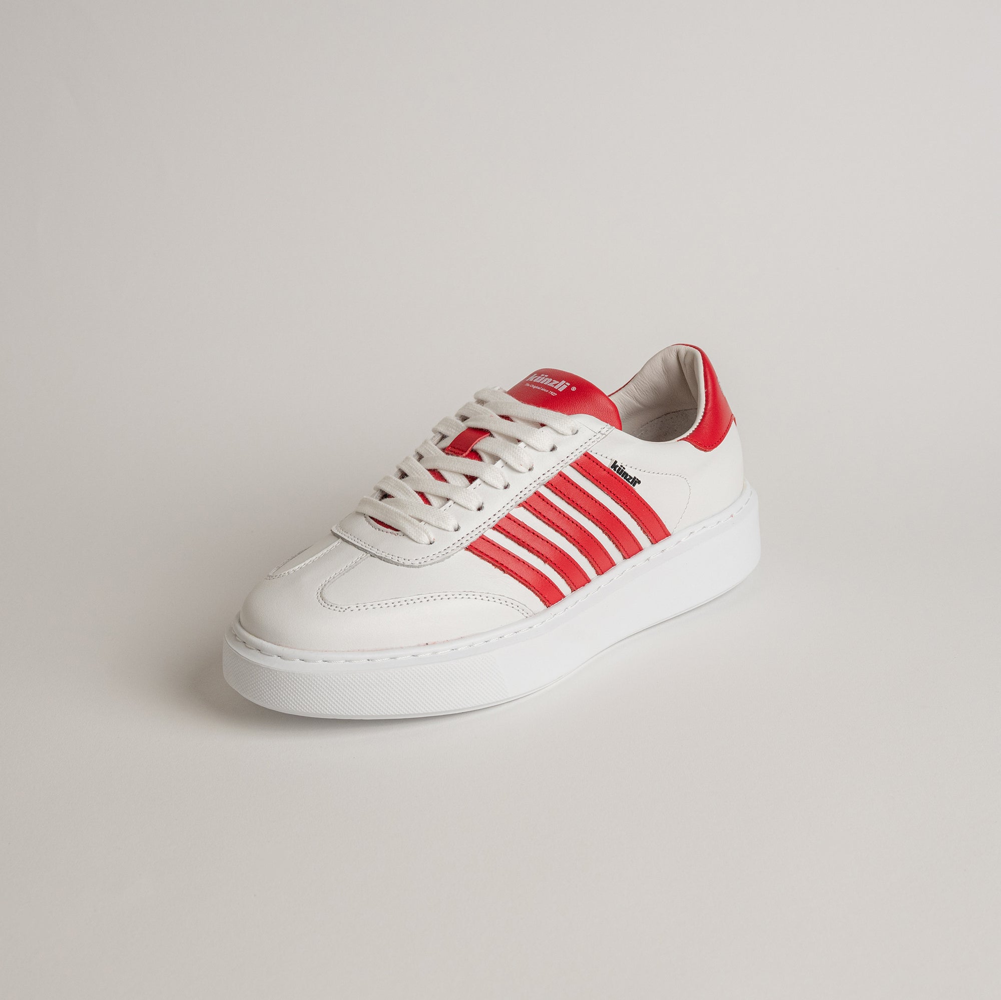 Weißer Kuenzli Schuh mit roten Streifen auf hellem Hintergrund, sportlich und modern.