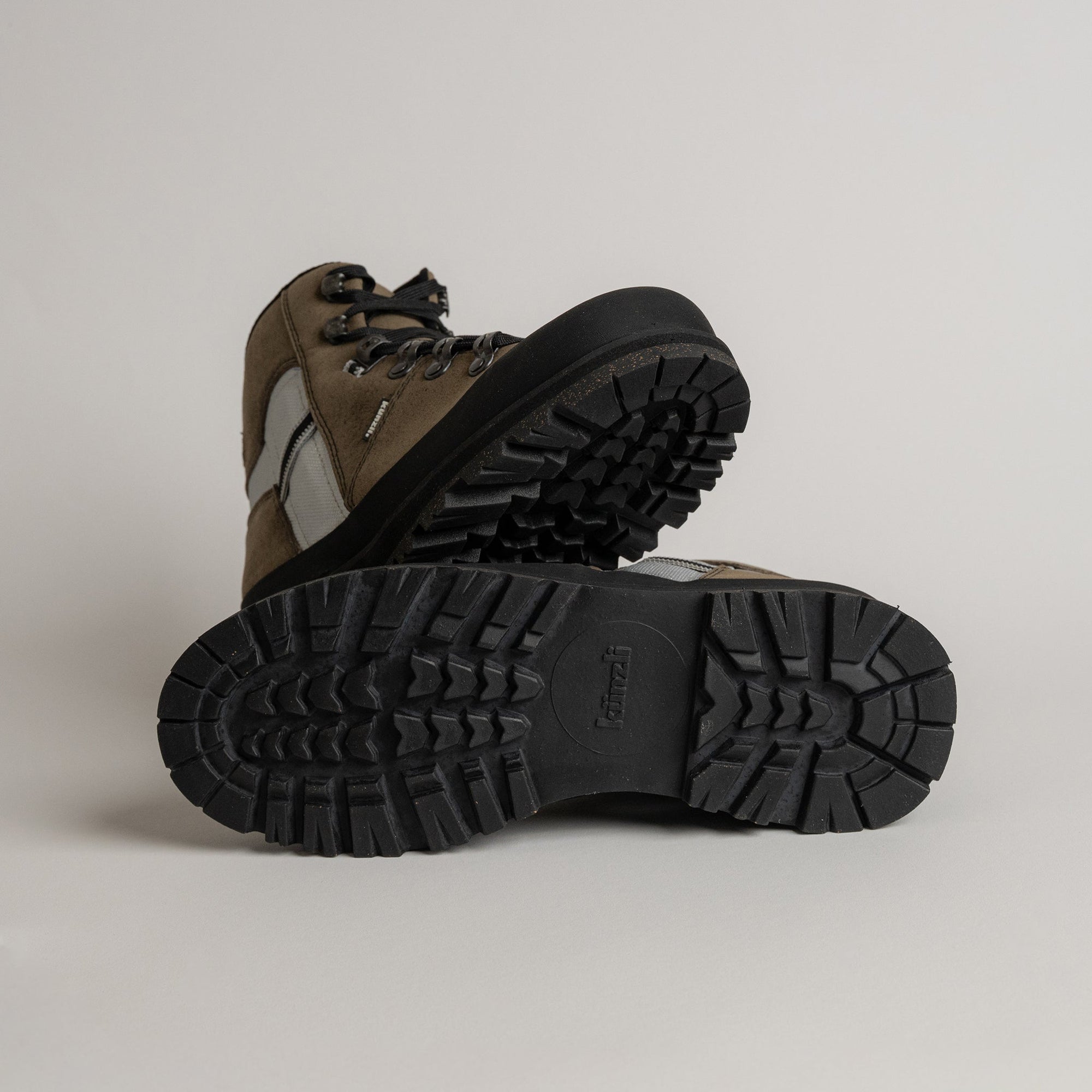 Wanderschuhe von Kuenzli Schuhe mit robustem Profil in Braun und Schwarz auf hellem Hintergrund.