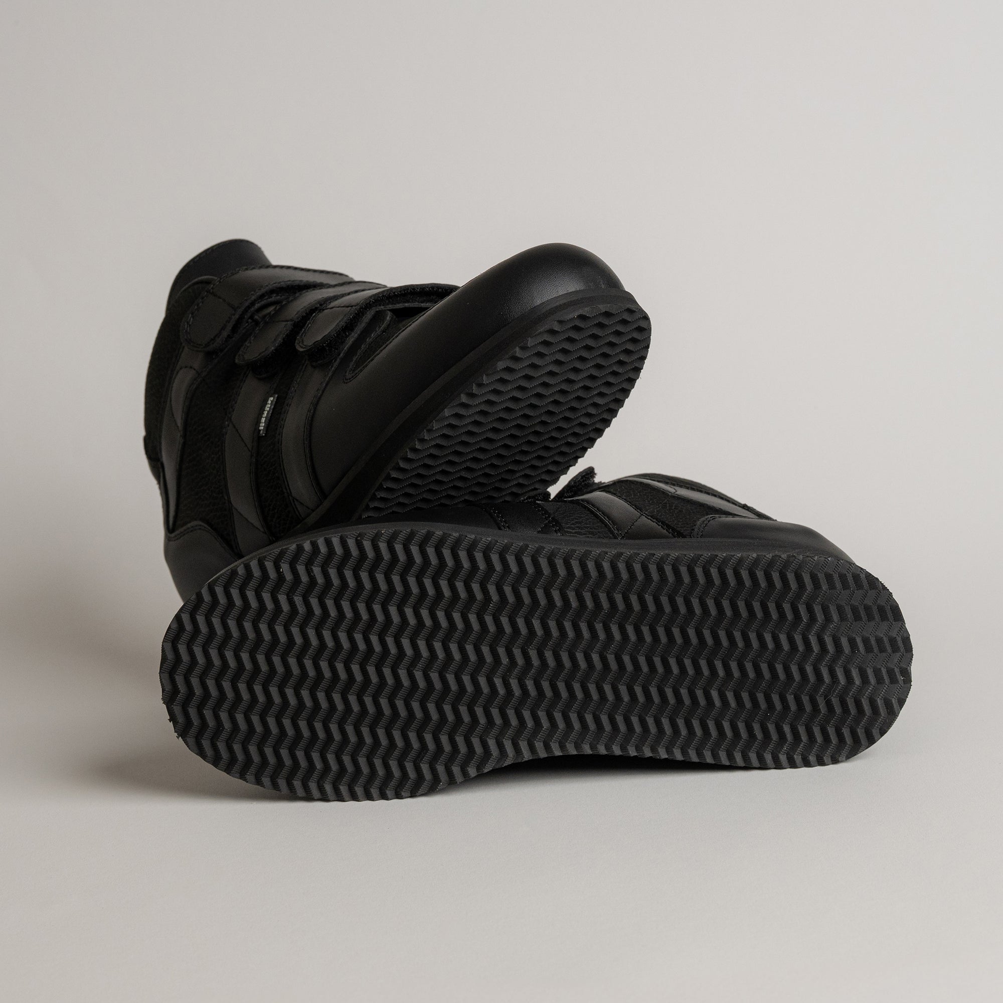 Schwarze Kuenzli Schuhe mit rutschfester Sohle auf hellem Hintergrund präsentiert.
