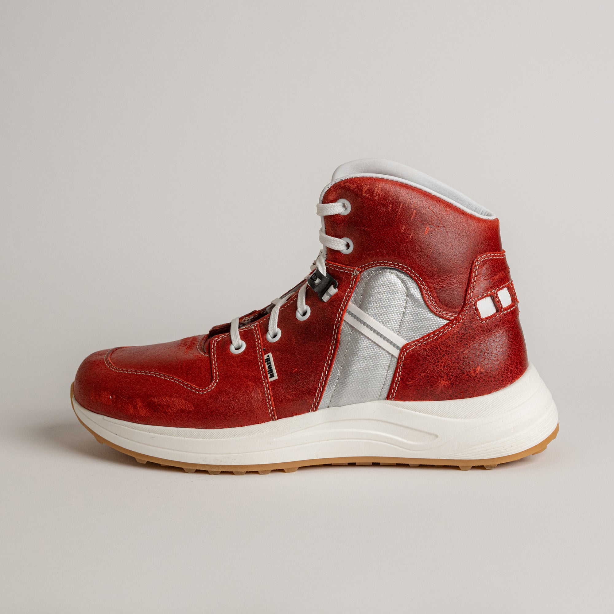 Roter Lederschuh von Kuenzli Schuhe mit weißer Sohle und silbernen Details.