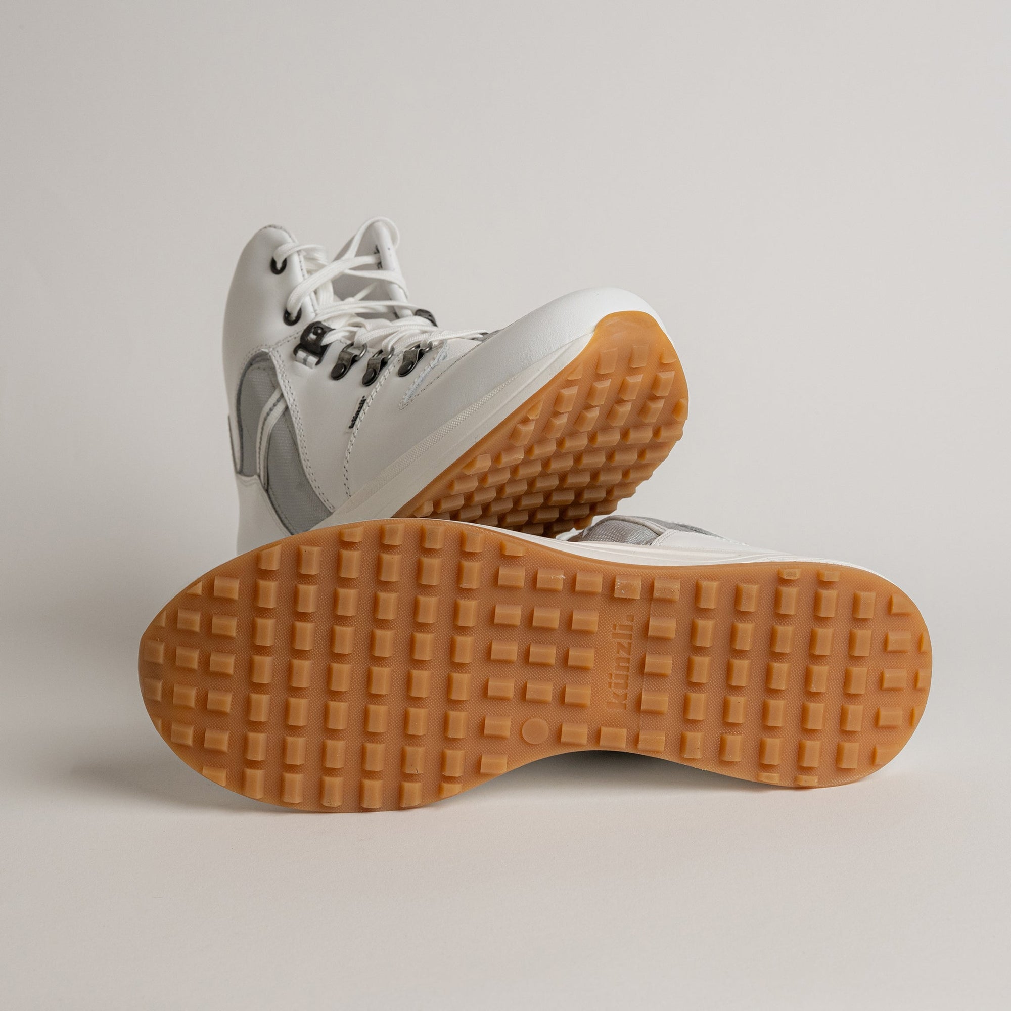 Weiße Kuenzli Schuhe mit rutschfester Sohle, ideal für Outdoor-Aktivitäten und Waldtraining.