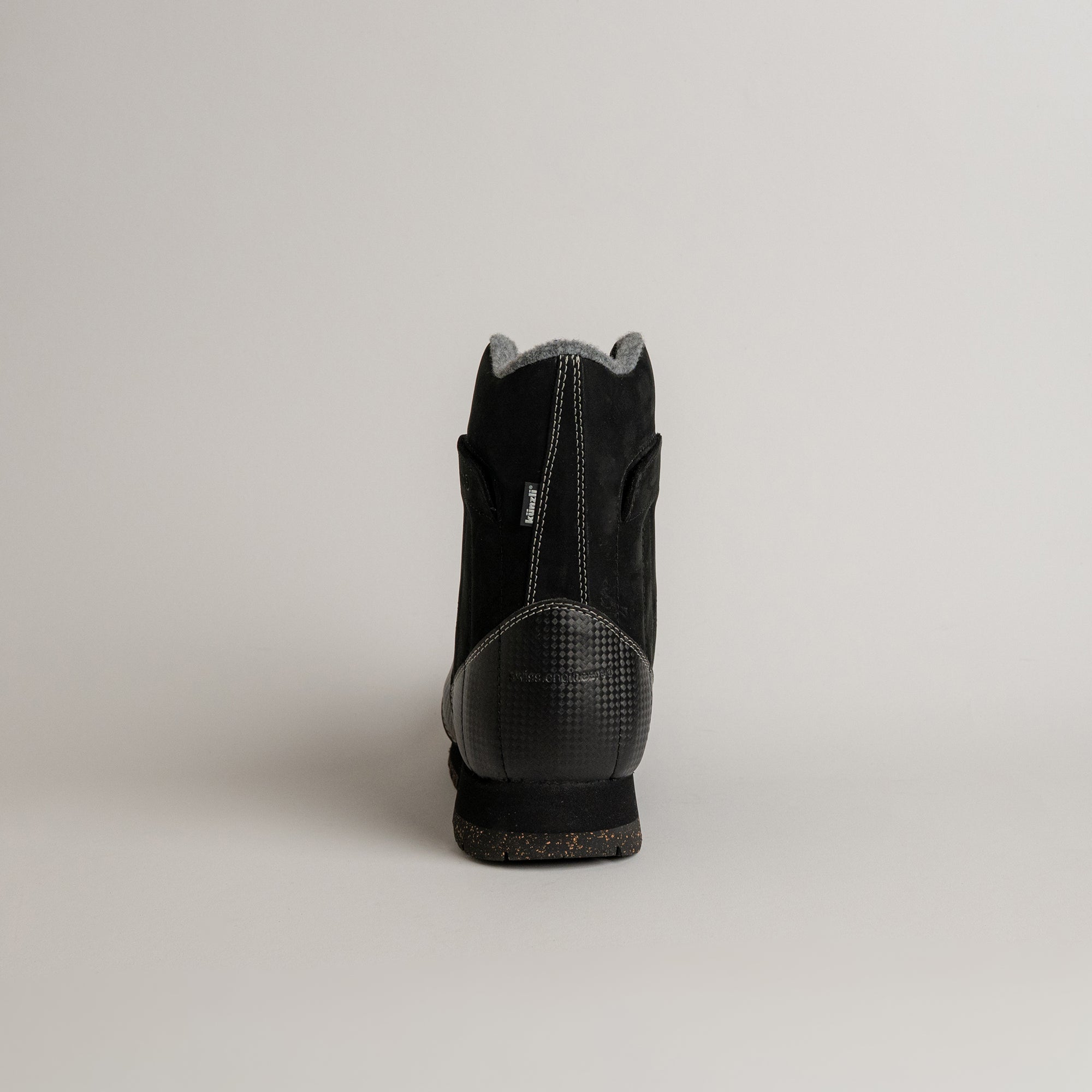 Schwarzer Kuenzli Schuh aus Leder mit grauem Innenfutter, Rückansicht auf hellem Hintergrund.