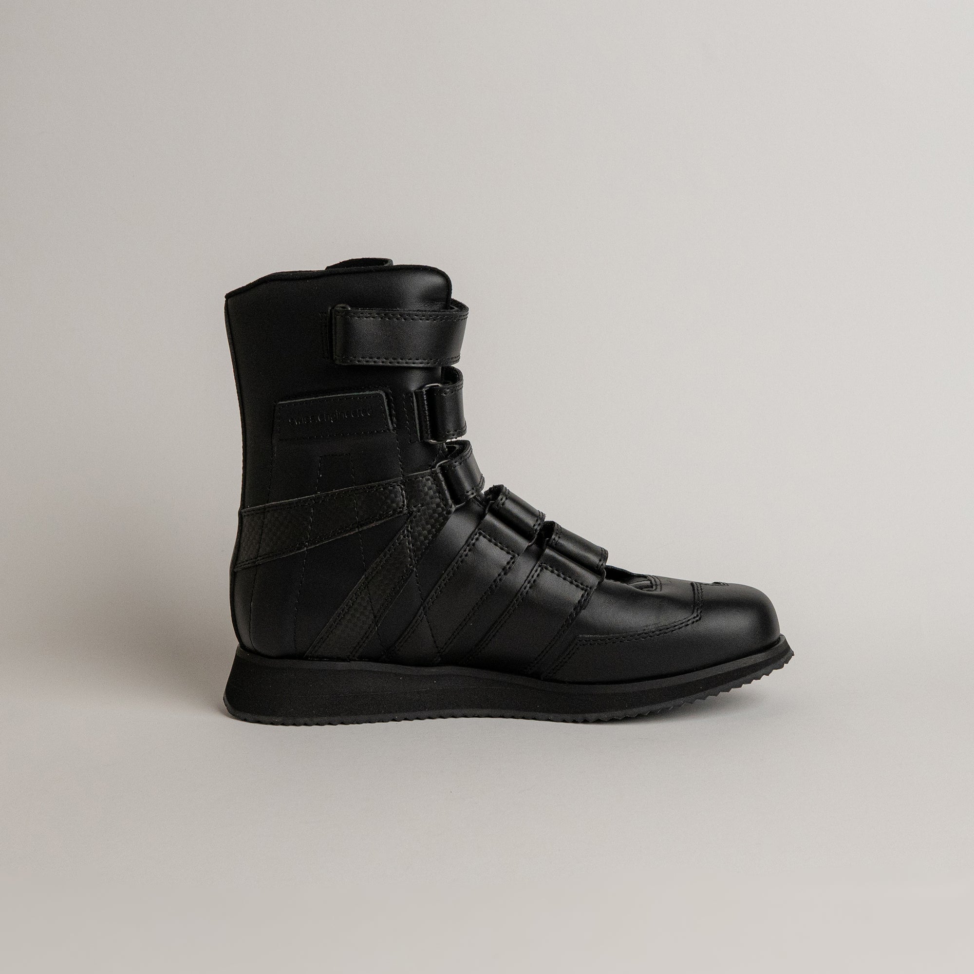 Schwarzer Lederstiefel von Kuenzli Schuhe mit Klettverschlüssen auf hellem Hintergrund.