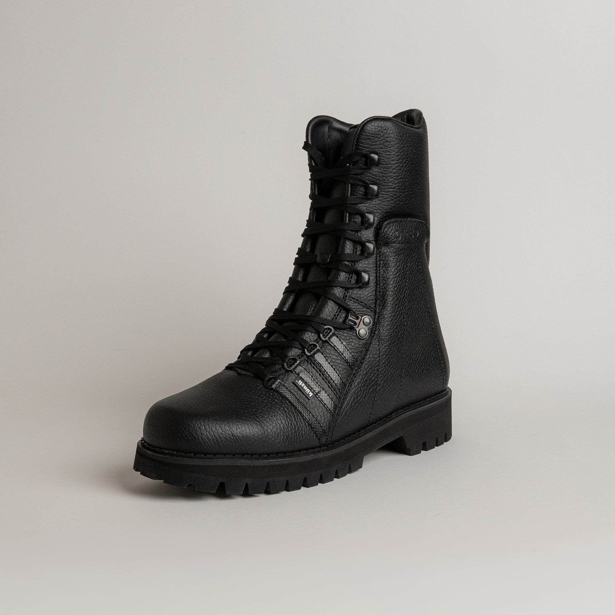 Schwarzer Lederstiefel von Kuenzli Schuhe mit robuster Sohle auf grauem Hintergrund.