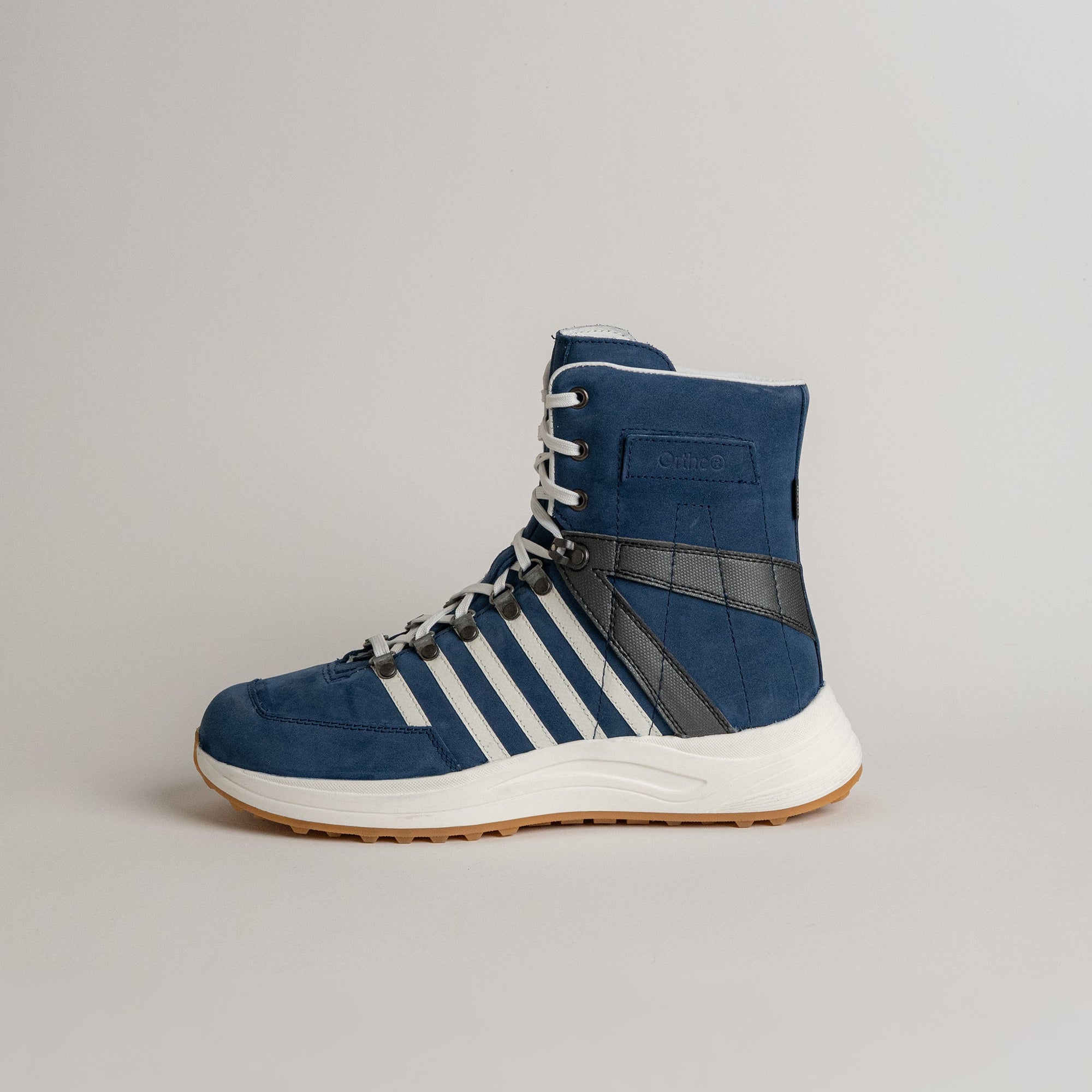 Blauer Kuenzli Schuhe Sneaker mit weißen Streifen und schwarzem Detail auf hellem Hintergrund.