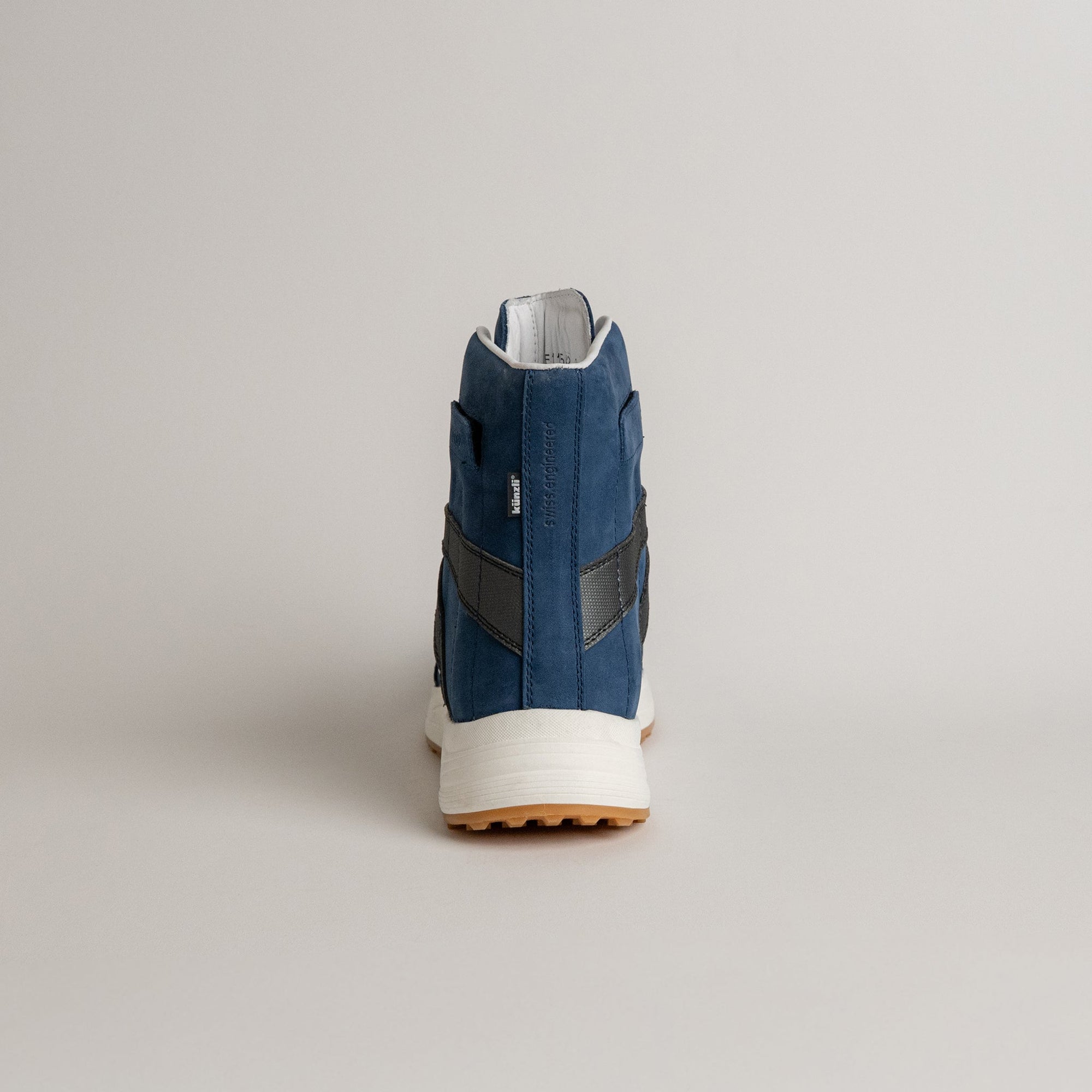 Ein blauer Kuenzli Schuhe Sneaker aus Leder, Rückansicht, auf grauem Hintergrund.