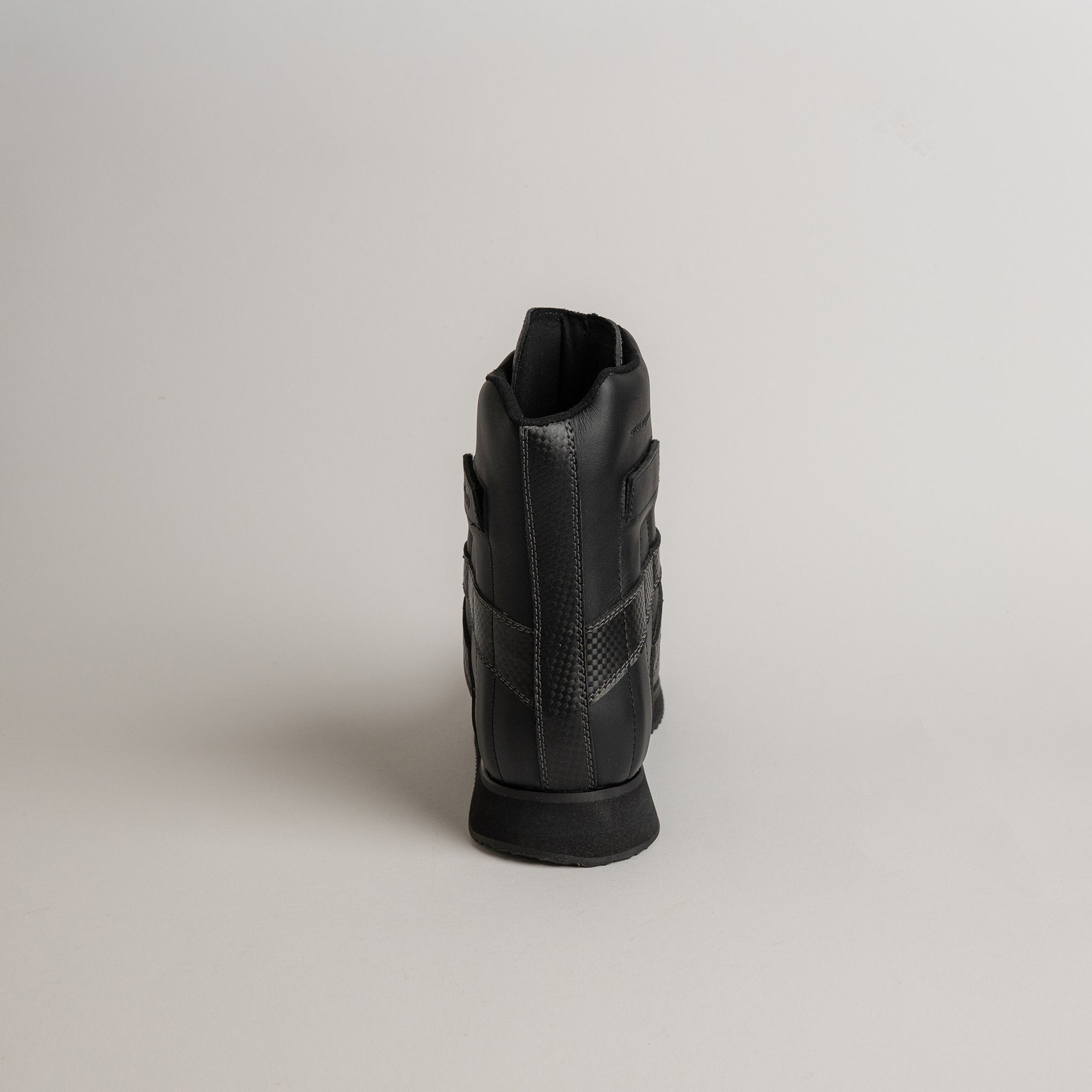 Schwarzer Lederschuh von Kuenzli Schuhe, Rückansicht, auf neutralem Hintergrund.